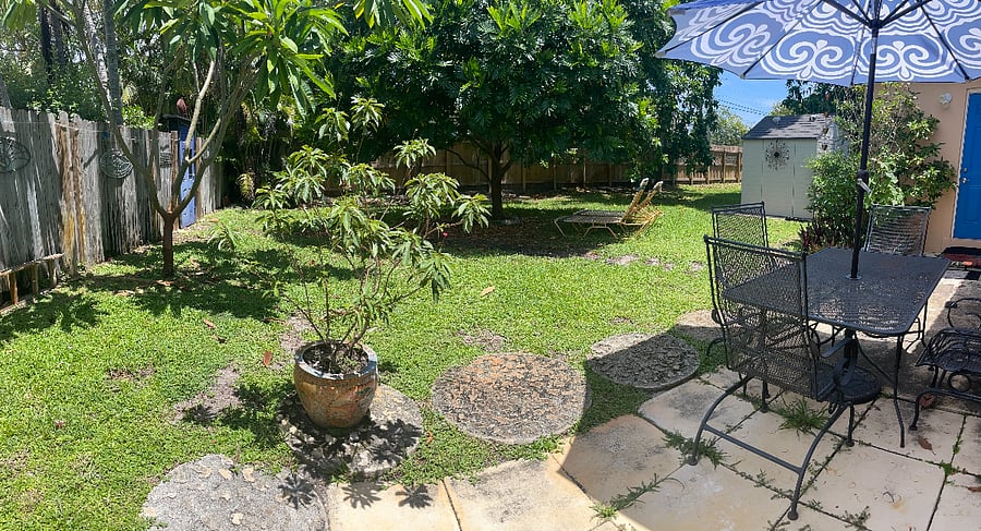 Your patio looking across tree shaded fenced backyard