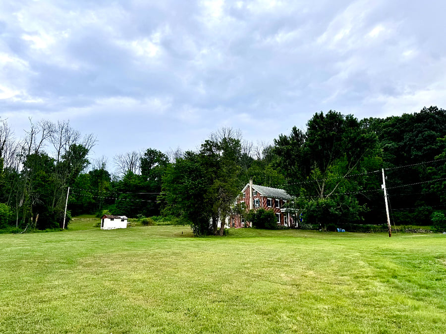 Mountainside stretches up behind house.