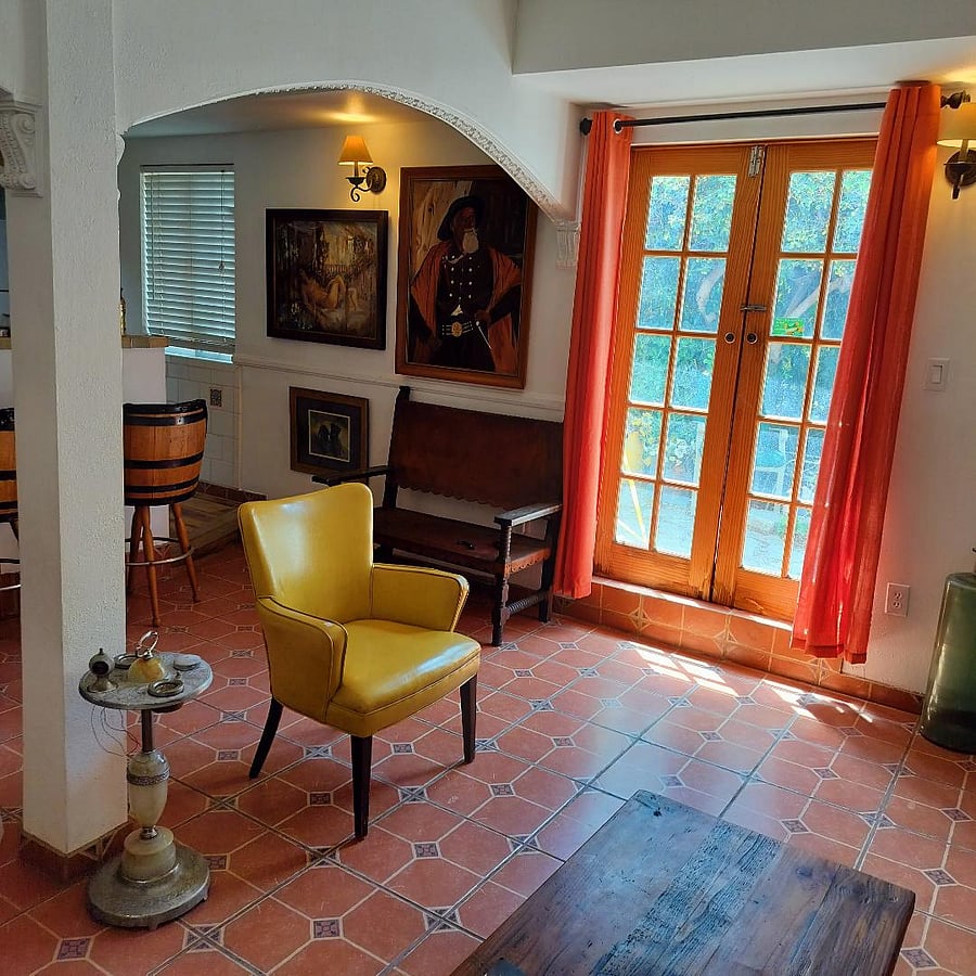 Bright and spacious living area features mediterrainian shabby chic with French doors.