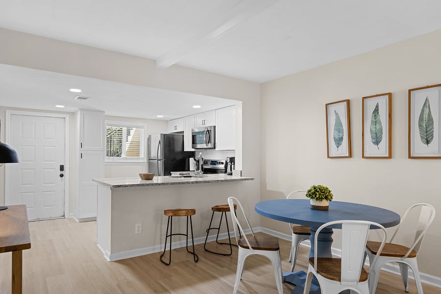 The dining area features a table with seating for four, seamlessly connected to the kitchen and living room, creating a welcoming space for meals and gatherings.