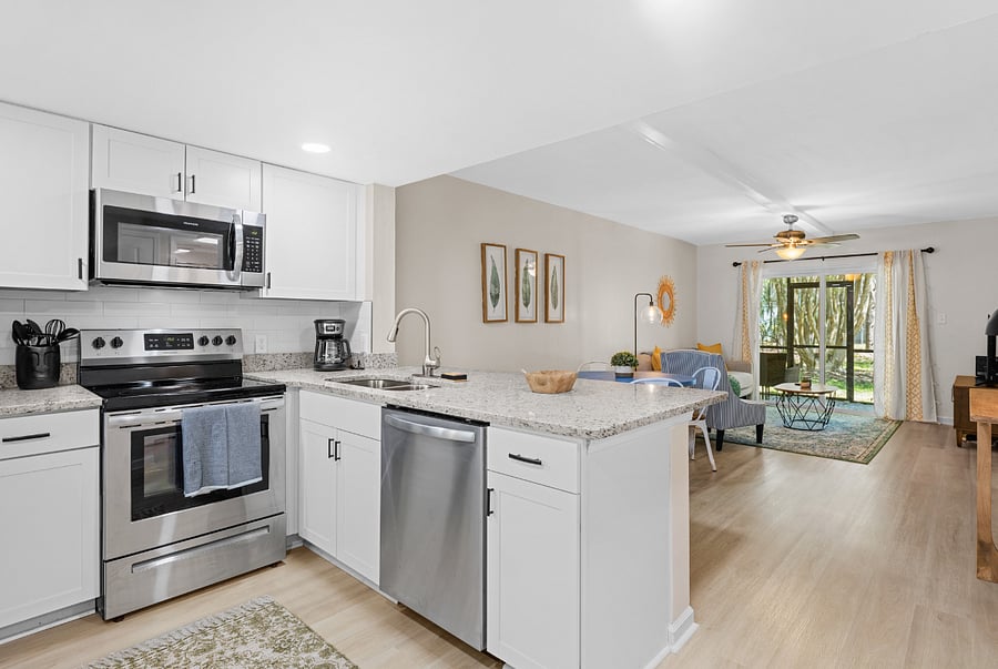 The kitchen boasts a contemporary design with stainless steel appliances, spacious granite countertops, and a central island, perfect for preparing and enjoying meals.