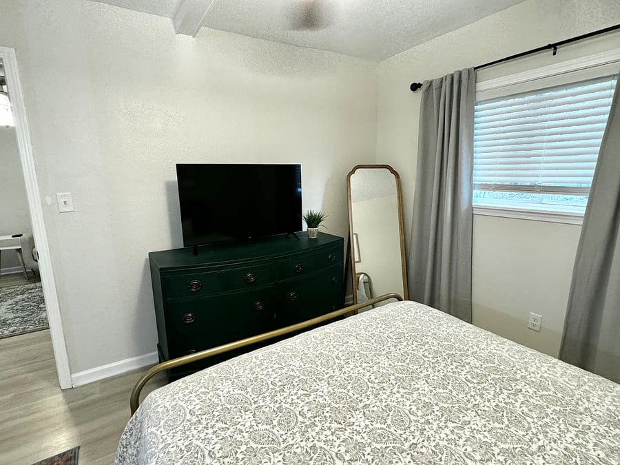 The bedroom features a cozy queen bed, Smart TV and an ensuite full bathroom, providing a comfortable and private retreat.