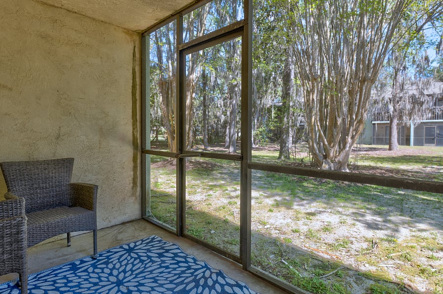 The private screened porch offers a comfortable seating area with a beautiful view of the surrounding outdoor landscape, perfect for relaxation and enjoying fresh air.