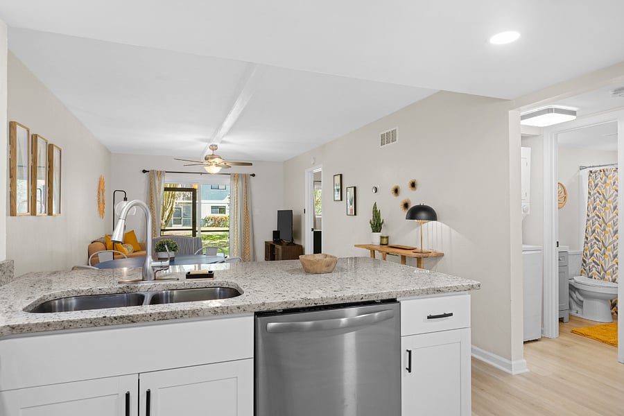 The kitchen boasts a contemporary design with stainless steel appliances, spacious granite countertops, and a central island, perfect for preparing and enjoying meals.