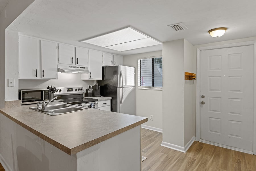 The kitchen boasts a modern design with stainless steel appliances, spacious granite countertops, and a central island for convenient meal preparation.
