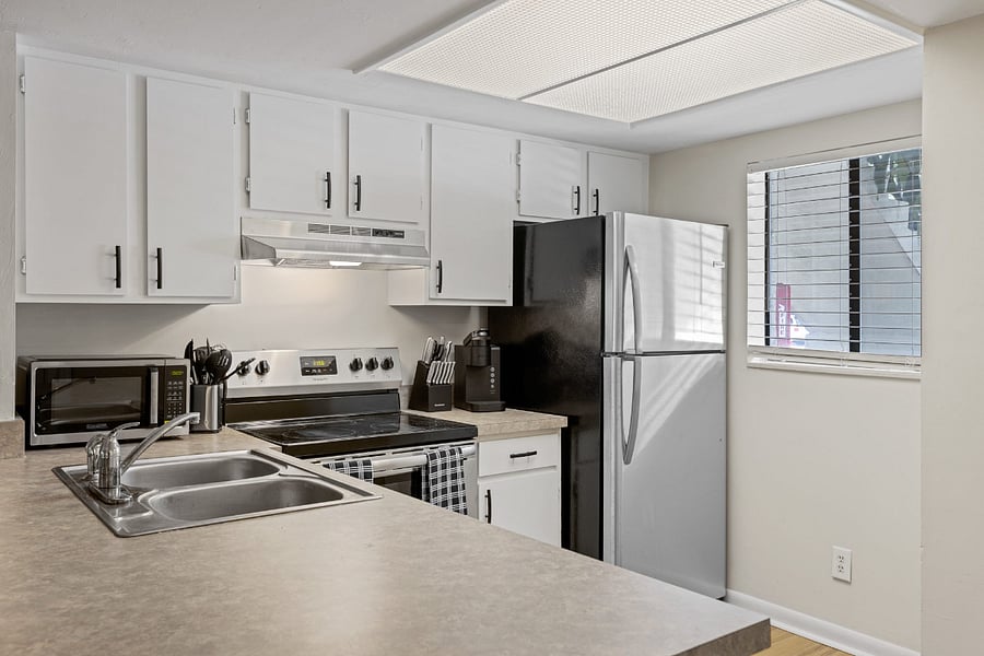 The kitchen boasts a modern design with stainless steel appliances, spacious granite countertops, and a central island for convenient meal preparation.