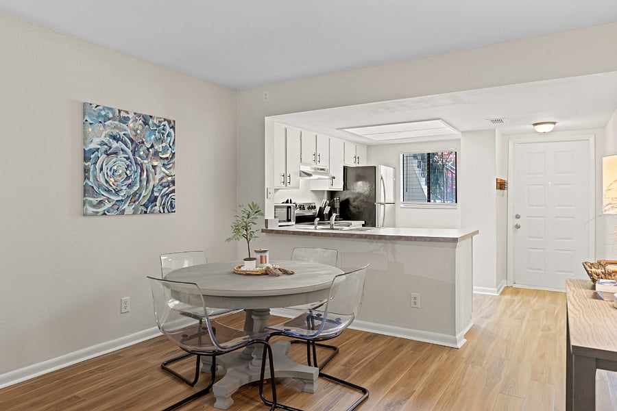 The dining area, seamlessly connected to the kitchen, offers a stylish table with seating for four, perfect for enjoying meals together.