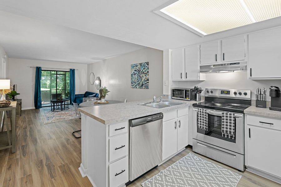 The kitchen boasts a modern design with stainless steel appliances, spacious granite countertops, and a central island for convenient meal preparation.