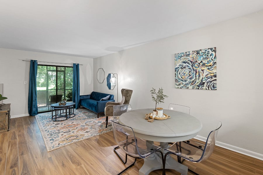 The living room features a cozy seating area, a smart TV, and access to a private screened porch with serene outdoor views.