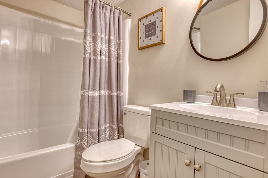 The full bathroom features a tub/shower combo, a vanity with a mirror, and includes all necessary towels, providing a convenient and relaxing space to get ready for the day or unwind in the evening.