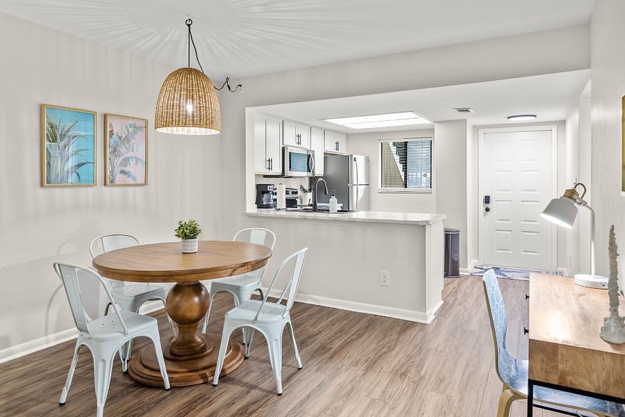 The dining area features a stylish table with seating for four, seamlessly connected to the kitchen for convenient and enjoyable meals.