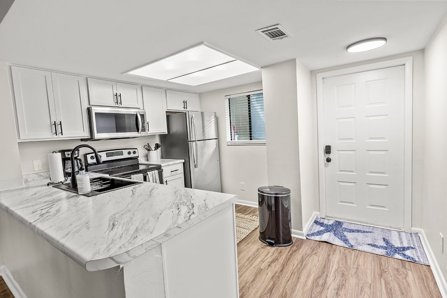 The kitchen is equipped with modern stainless steel appliances, spacious granite countertops, and a central island, perfect for preparing and enjoying meals.