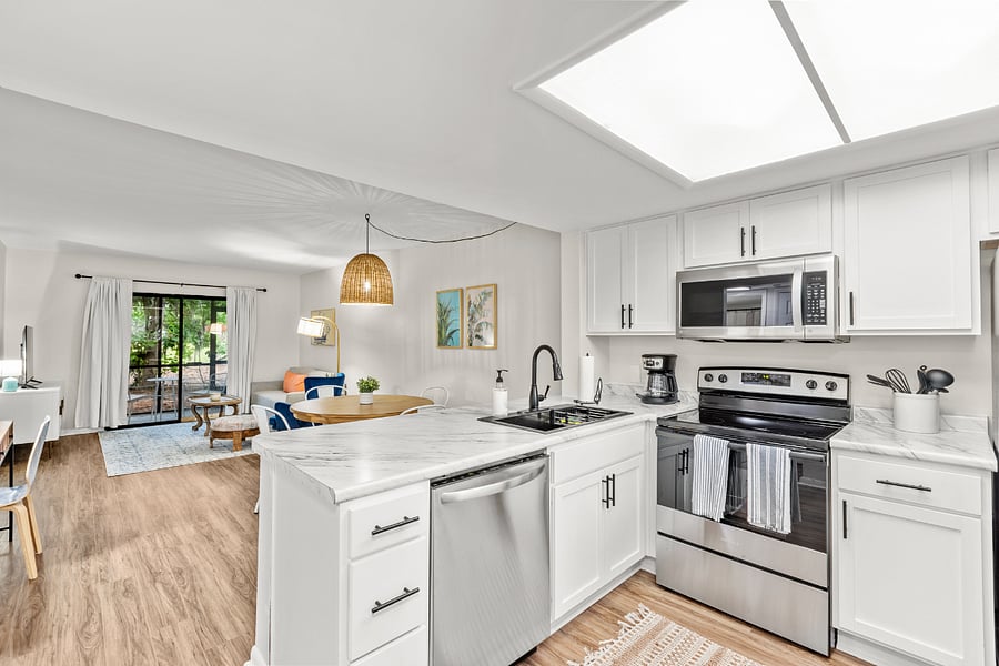 The kitchen is equipped with modern stainless steel appliances, spacious granite countertops, and a central island, perfect for preparing and enjoying meals.