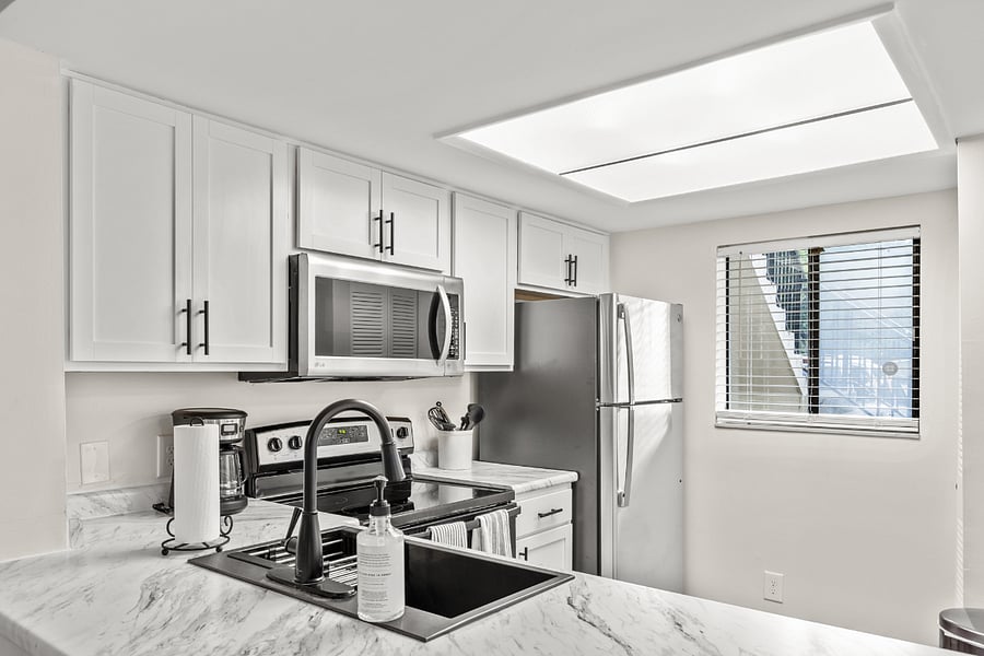 The kitchen is equipped with modern stainless steel appliances, spacious granite countertops, and a central island, perfect for preparing and enjoying meals.