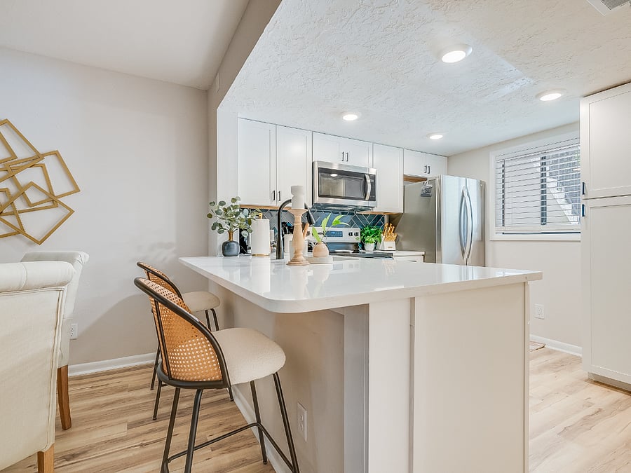 The dining area at Bluffside Charm offers versatility and comfort, with a stylish bar that seats two and a charming table with seating for four, making it perfect for both casual meals and intimate gatherings.