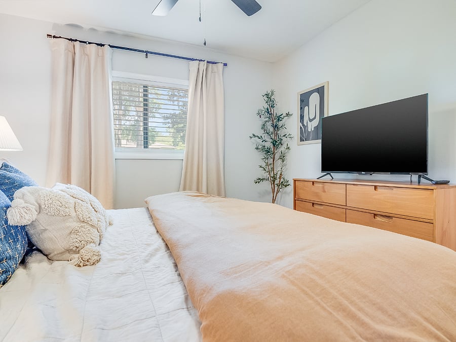 The primary bedroom at Bluffside Charm is a peaceful oasis, complete with a plush queen bed, an ensuite bath, and a smart TV, perfect for unwinding in comfort and style.