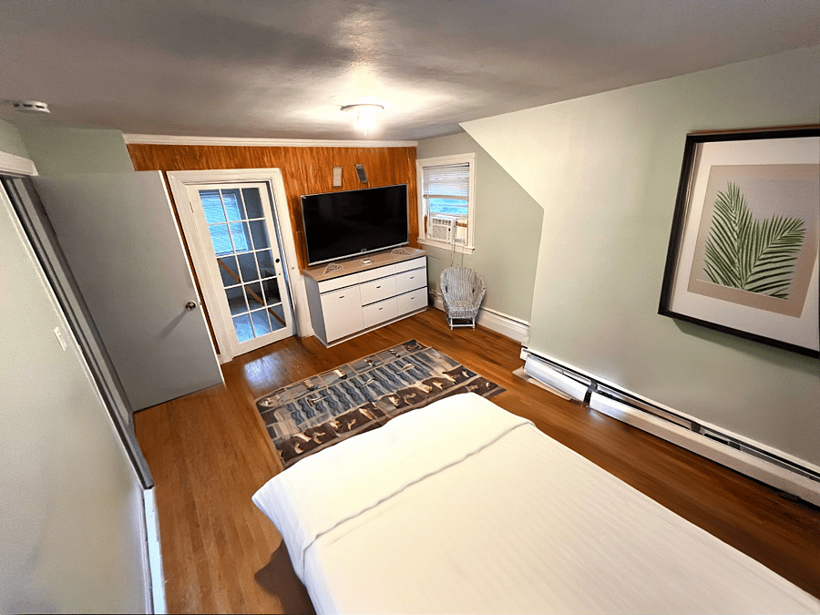 1st Bedroom featuring a huge walk in closet, tv and dresser, and modern bed! With AC and heating!