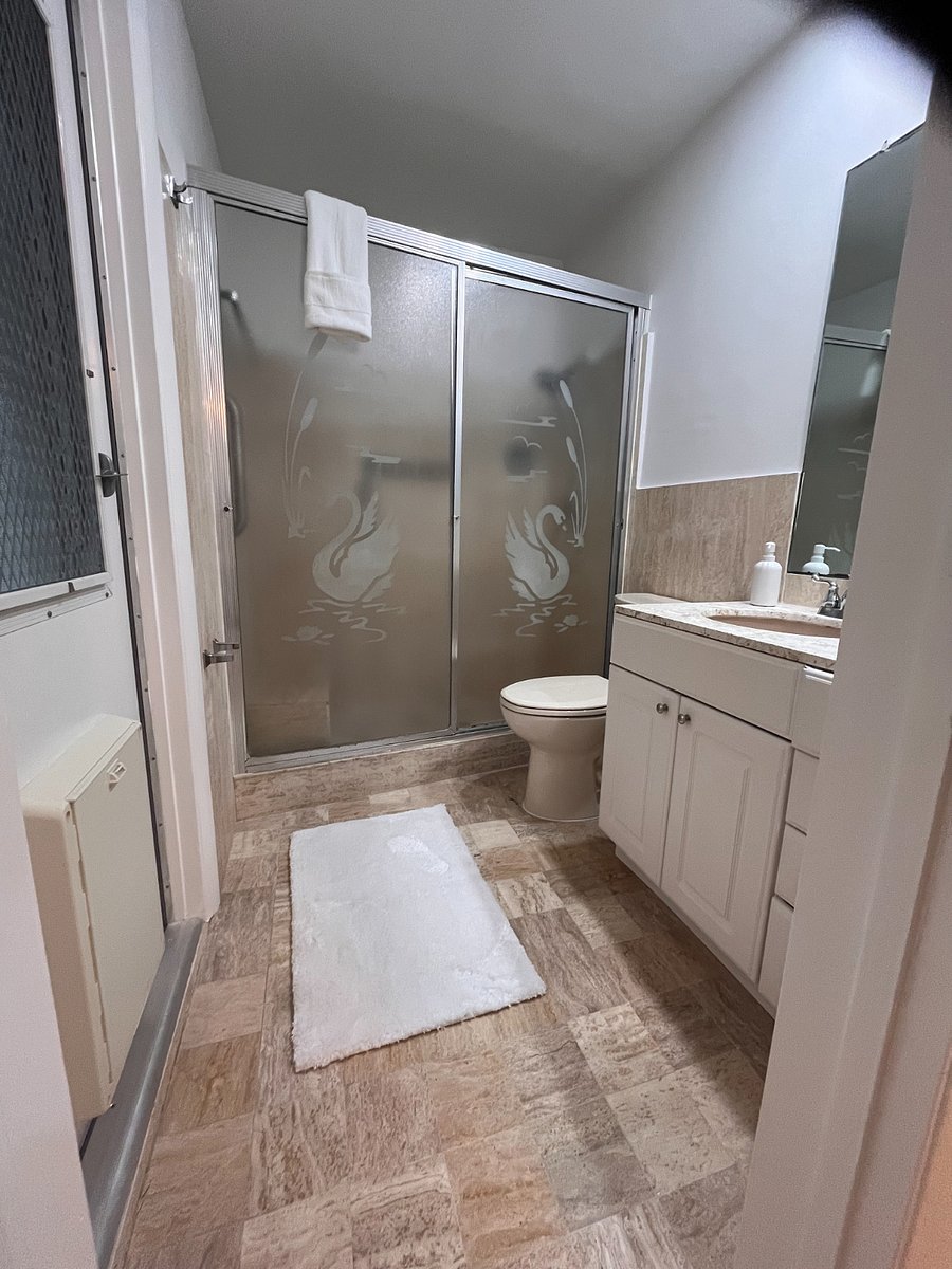 The primary bathroom has a doggy door to a screened patio and fenced-in yard.