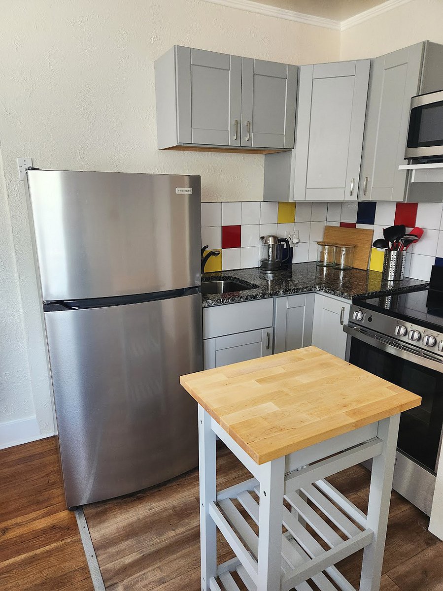 The kitchen features a new full-sized electric stove, refrigerator, microwave, a good amount of storage, a kitchen island and granite countertops.