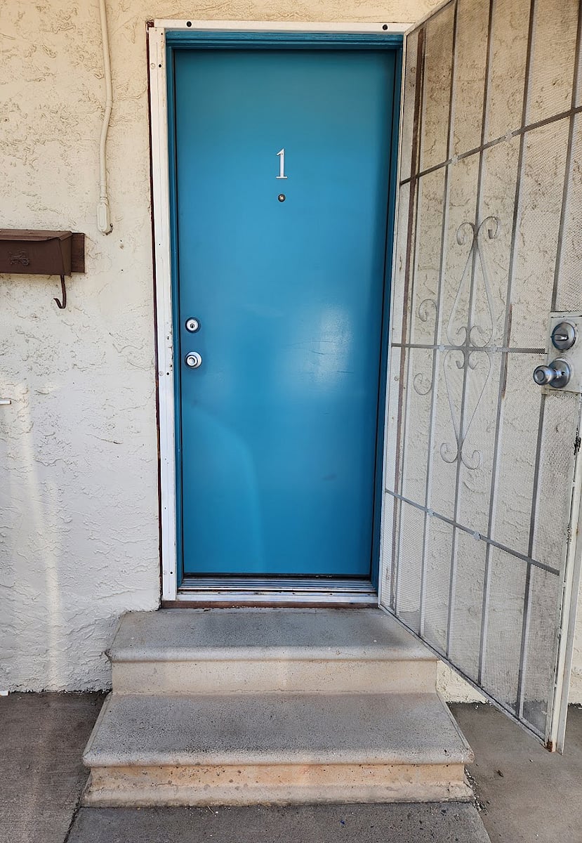 There are two shallow steps leading into the apartment. The entrance also features a security door.