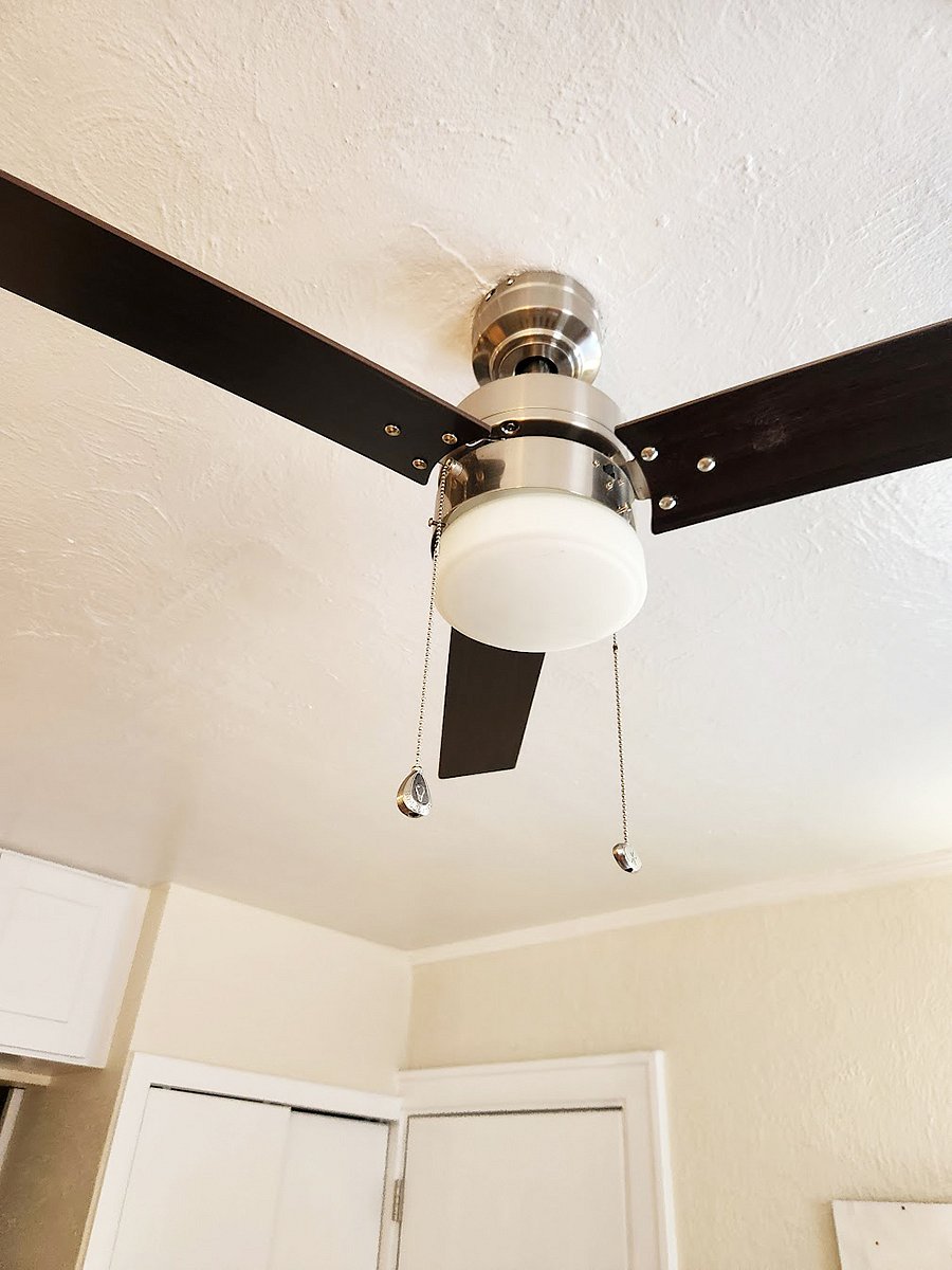 The bedroom and living room are equipped with ceiling fans