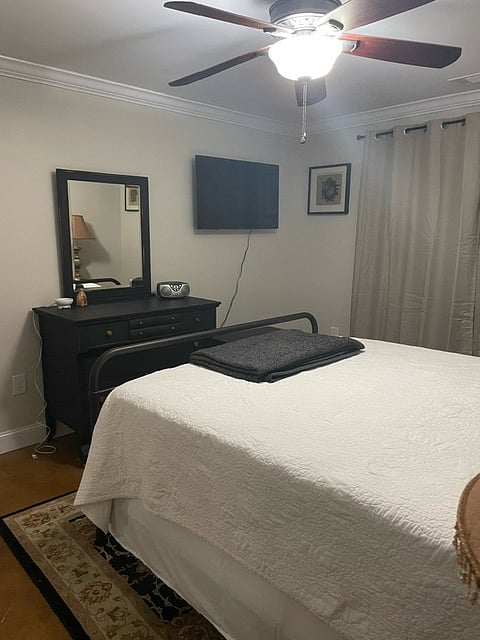 Bedroom with black out/sound proofing curtains, New Queen Size Mattress, dresser, 42in Roku TV w/cable, full closet, laundry hamper, iron, ironing board and hangers.