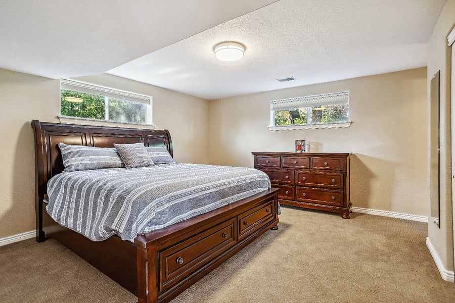 Bedroom with king sized bed and adjoining bathroom located in sunny walkout basement level. Has large closet.