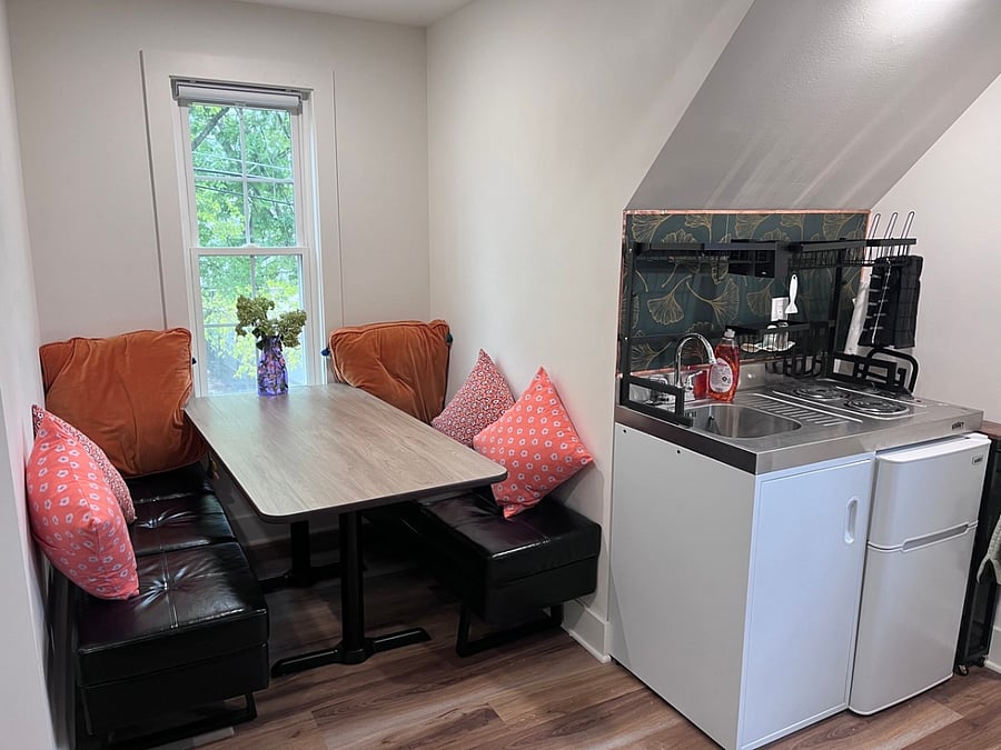 The dormer space has been utilized for a kitchen table and benches.  Each bench lifts to utilize more storage. 