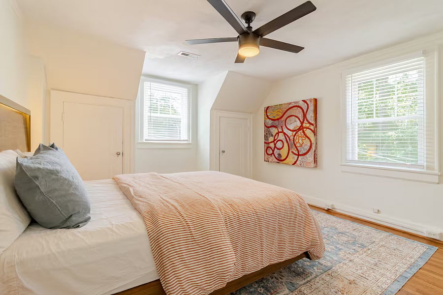 Enjoy the neighborhood view through the two windows in this bedroom. It also offers three small closets, each equipped with a chest of drawers, providing ample and convenient storage for your belongings during extended stays. 
