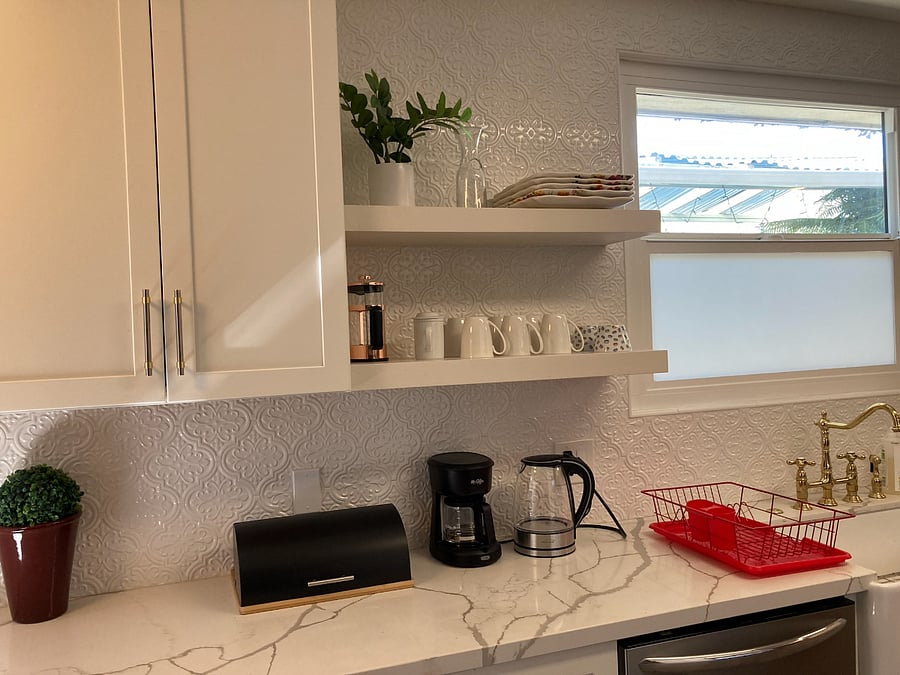 Fully equipped kitchen with microwave and toaster oven on other counter.