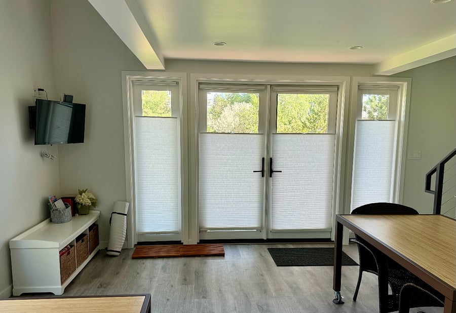 View of the front door with honeycomb shades; Smart TV; shoe cubby