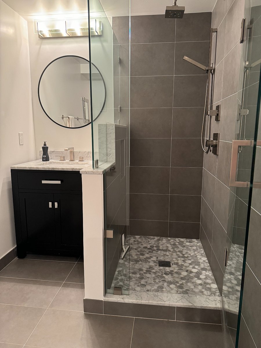Bathroom has rain shower and hand-held shower wand, marble finishes.