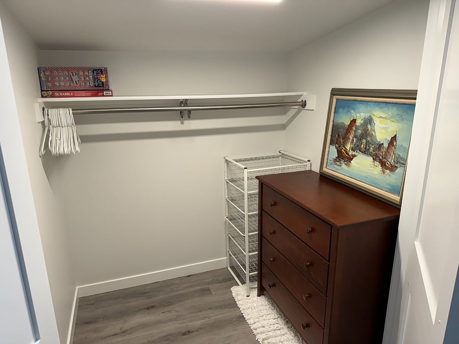 Upstairs master closet with drawers, hanging rod and shelf.