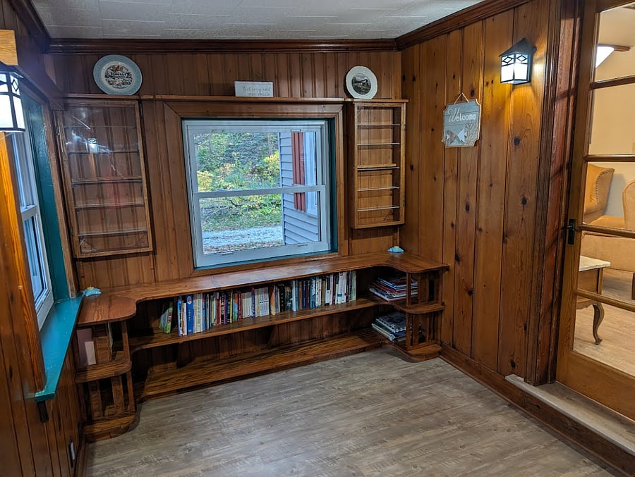 Front entryway with bookshelves. Door on the right leads to the living room.