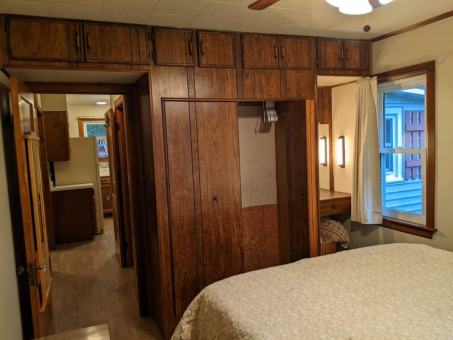 Door leading from Bedroom 1, Closet, shelf with make up mirror and lights.