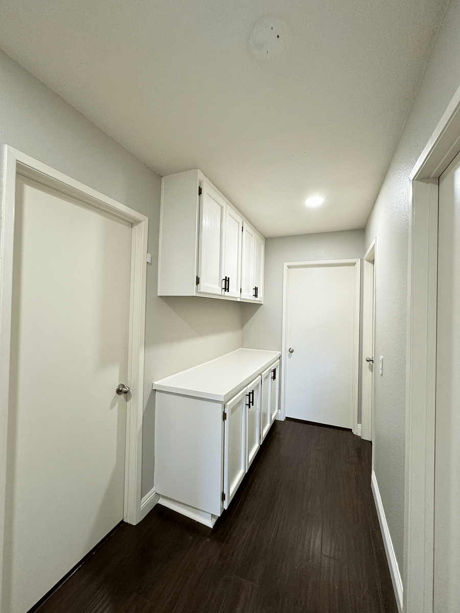 Hallway with lots of cabinets for storage.