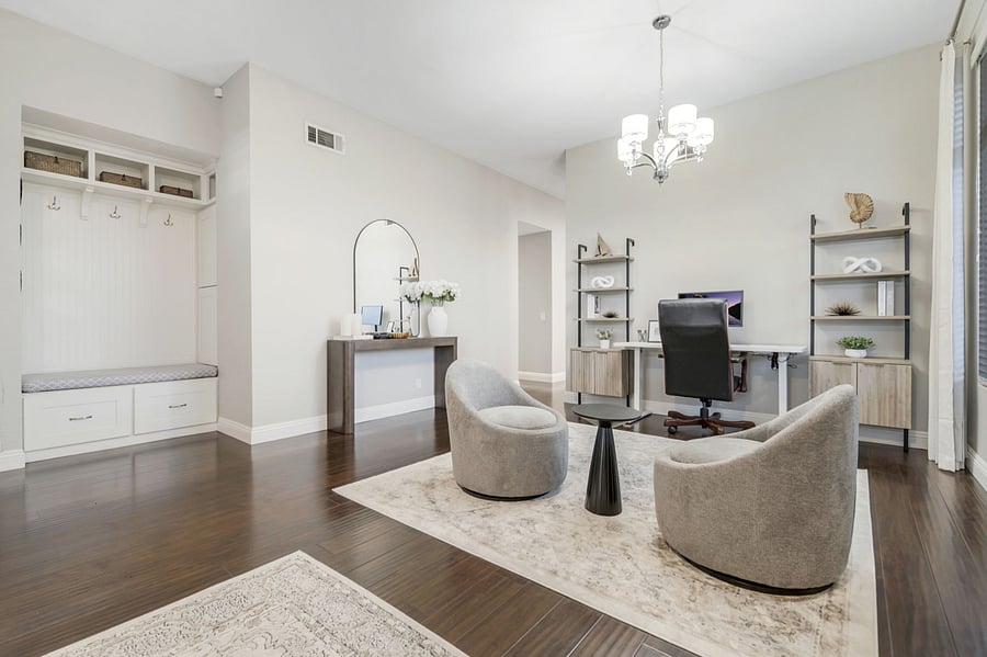 The workspace features swivel chairs for easy movement & flexibility. Its open layout seamlessly connects to the living room, creating a spacious, airy environment. This setup allows for multitasking and socializing, perfect for work & relaxation.