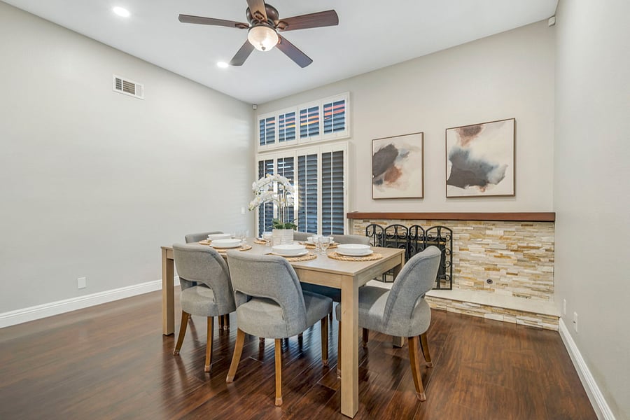 You can set the dining table for six with elegant plates, cutlery, and glassware. It includes bowls for sides and placemats. A beautiful centerpiece adds charm, creating a perfect setting for enjoying a delicious home-cooked meal together.The primary bedroom showcases a king-size bed and sliding doors that open to the backyard, flooding the space with natural light. The seamless indoor-outdoor flow enhances the rooms airy, serene atmosphere, perfect for a relaxing retreat.