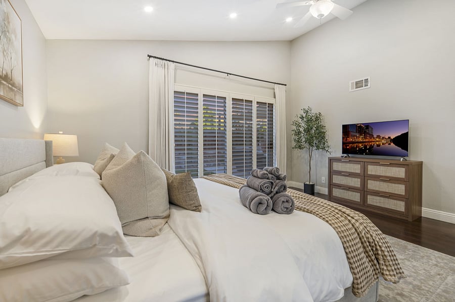 The primary bedroom features a 42" Smart TV, letting you enjoy your favorite shows while relaxing in the cozy bed. The room is thoughtfully designed sliding doors that open to the backyard, flooding the space with natural light for a serene retreat.