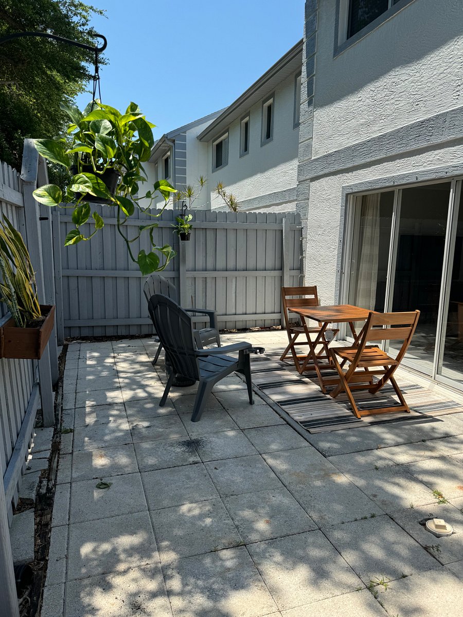 Fenced in patio with seating arrangement.