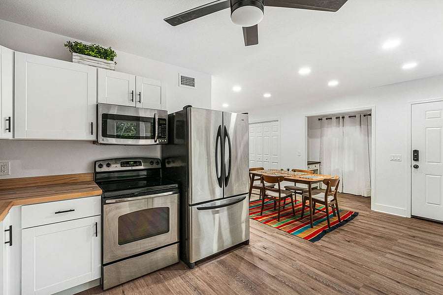 Spacious kitchen with full appliances, french door refrigerator, dishwasher, microwave, coffee maker, blender, silverware, plates and general appliances.