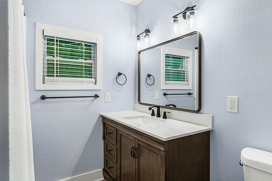 Common bathroom with bathtub and large vanity.