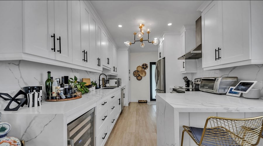 Kitchen Countertop, appliances, wine fridge, and door to outside. W/D in pantry doors next to microwave.