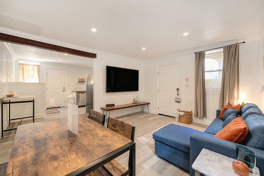 Bright and welcoming, this open-concept living and dining room offers a warm, modern space perfect for long stays. Natural light pours through windows, highlighting cozy furnishings and dining area. It feels like homea perfect home away from home.