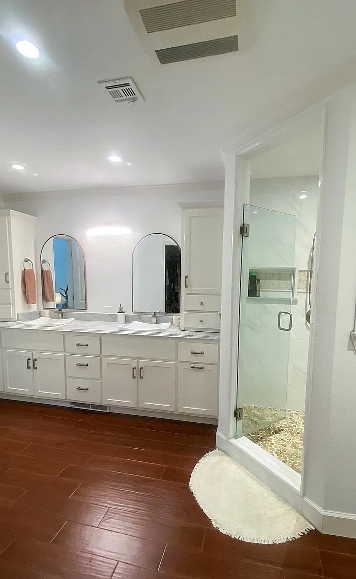 Primary Suite bathroom with his and her sinks, large walk in closet located to the left.