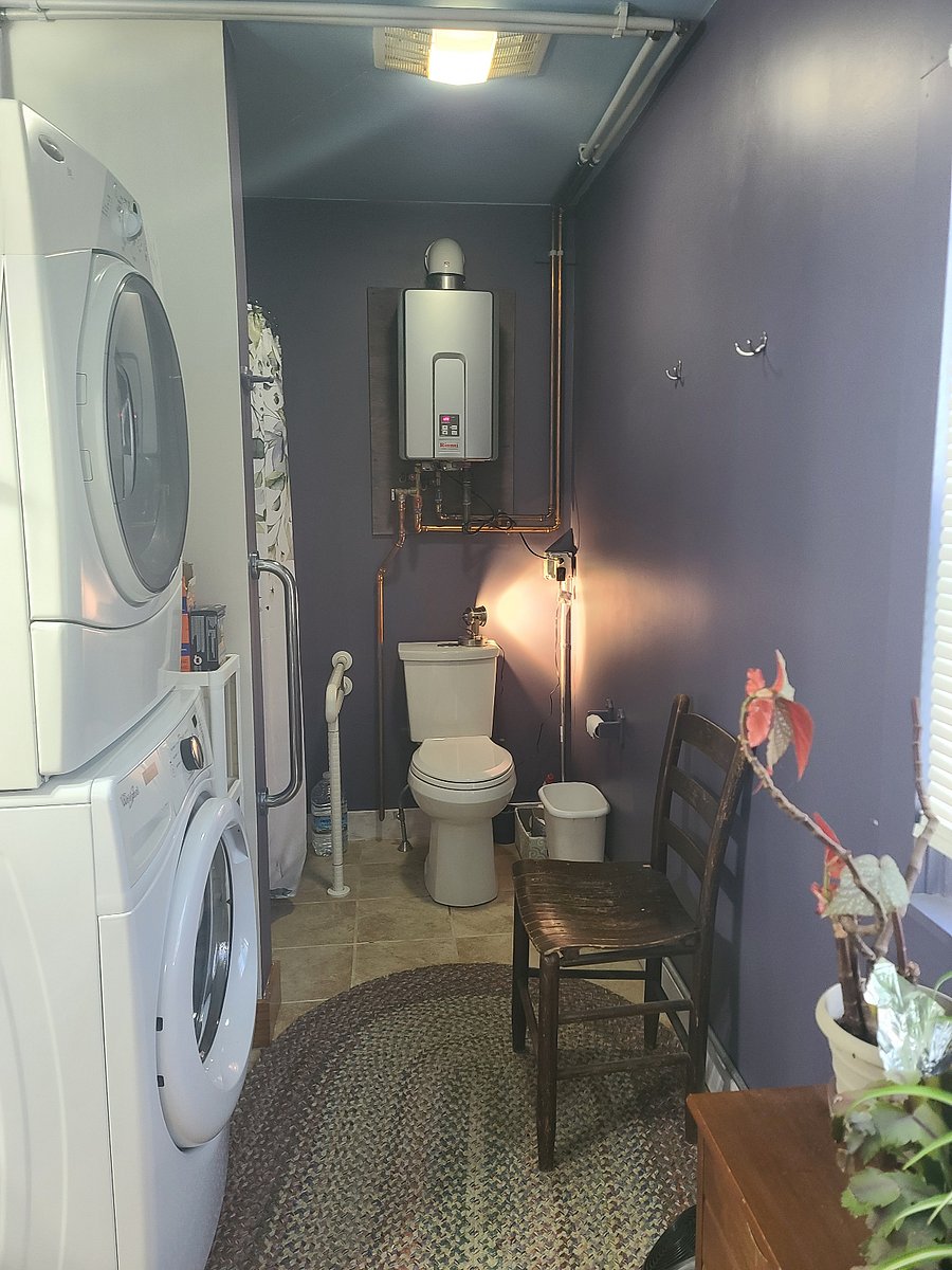 Into the bathroom. Full sized walk in shower on the left after the washer and dryer. Notice the tankless water heater. Never run out of hot water!