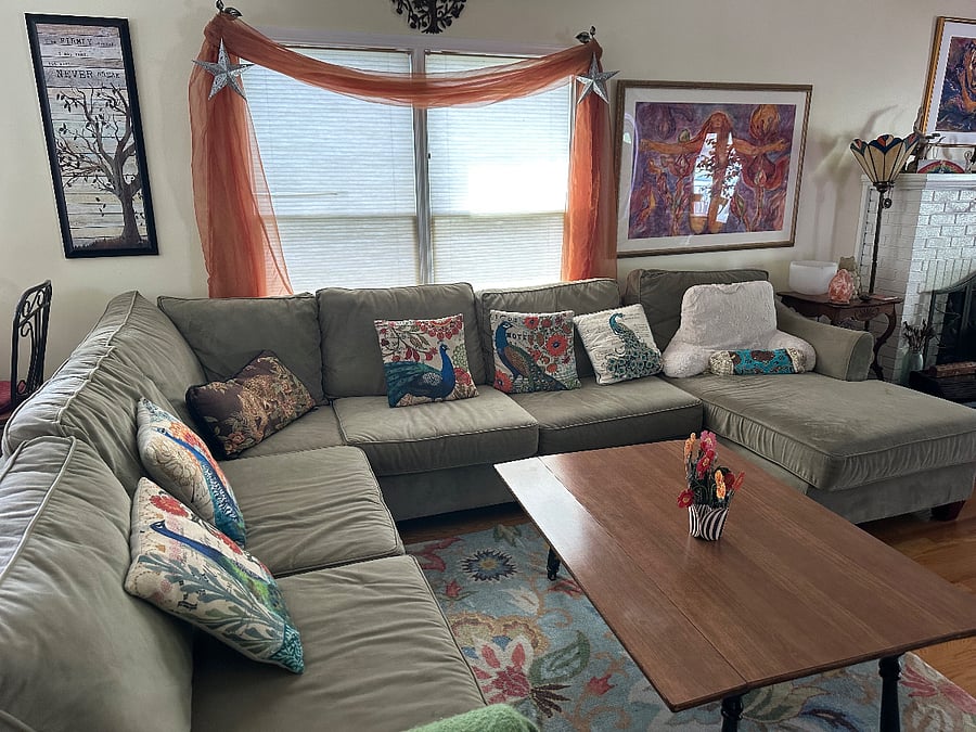 Modular Couch next to kitchen in open floor plan. Hardwood floors.