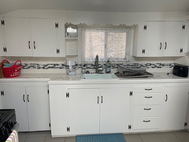 Original, old-style cabinets and skirting over the widow.