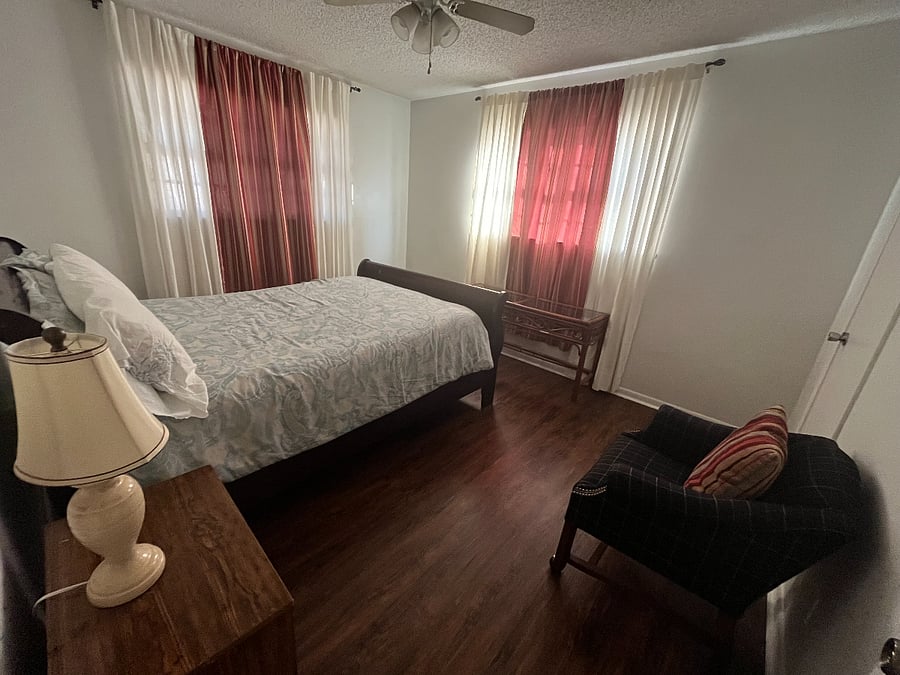 Corner bedroom with a cozy queen-size bed  bright, quiet, and perfect for relaxing after a long day.