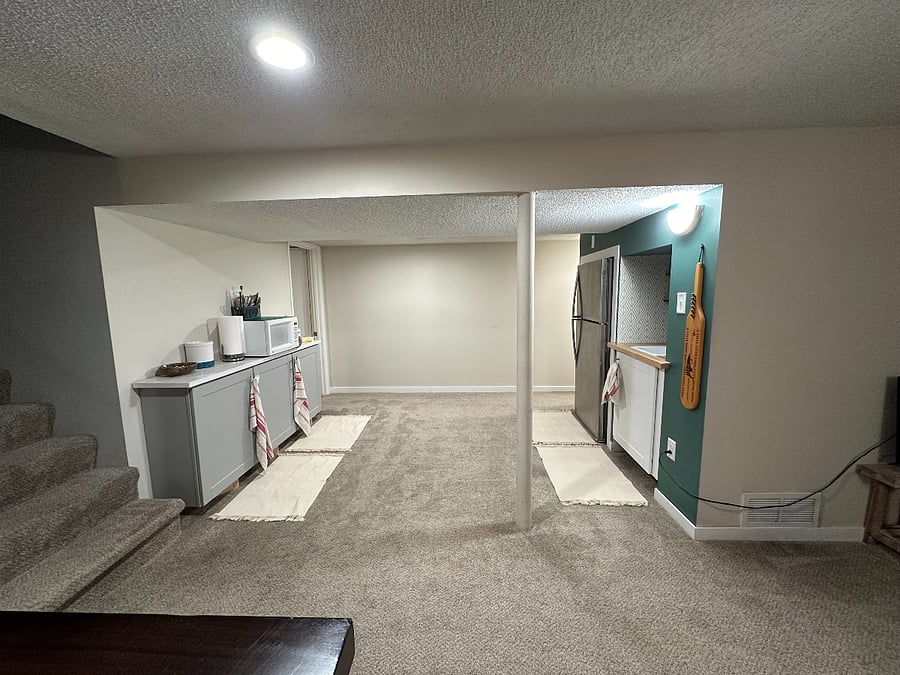 Lower level kitchenette with a full-sized fridge and freezer, sink, cabinets, countertop for prep, small appliances, and dishes!